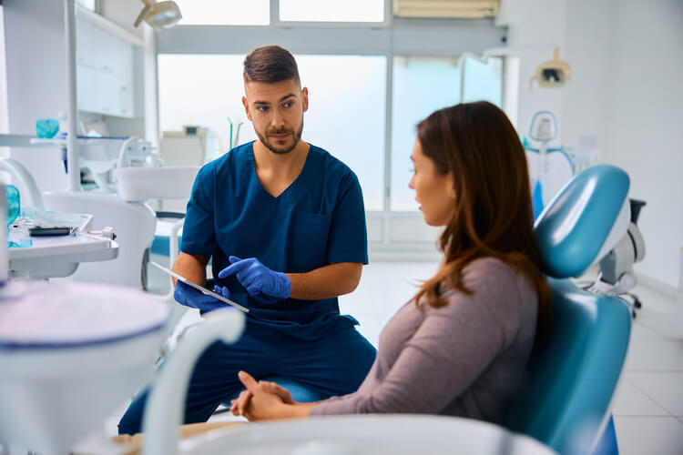 A male endodontist reviewing an x-ray with a female patient before an endodontic apicoectomy