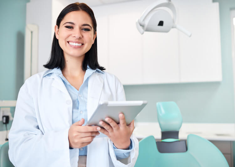 A young female endodontist smiling before seeing a patient during a first visit