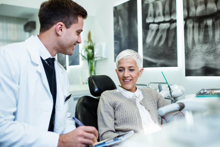 An endodontist reviewing post op instructions with a middle aged female patient