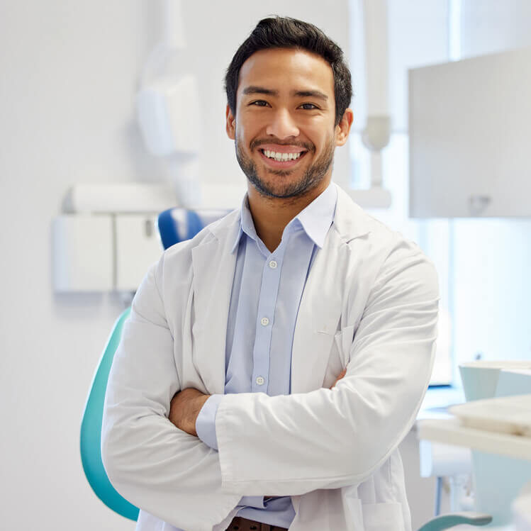 A young adult male endodontist smiling